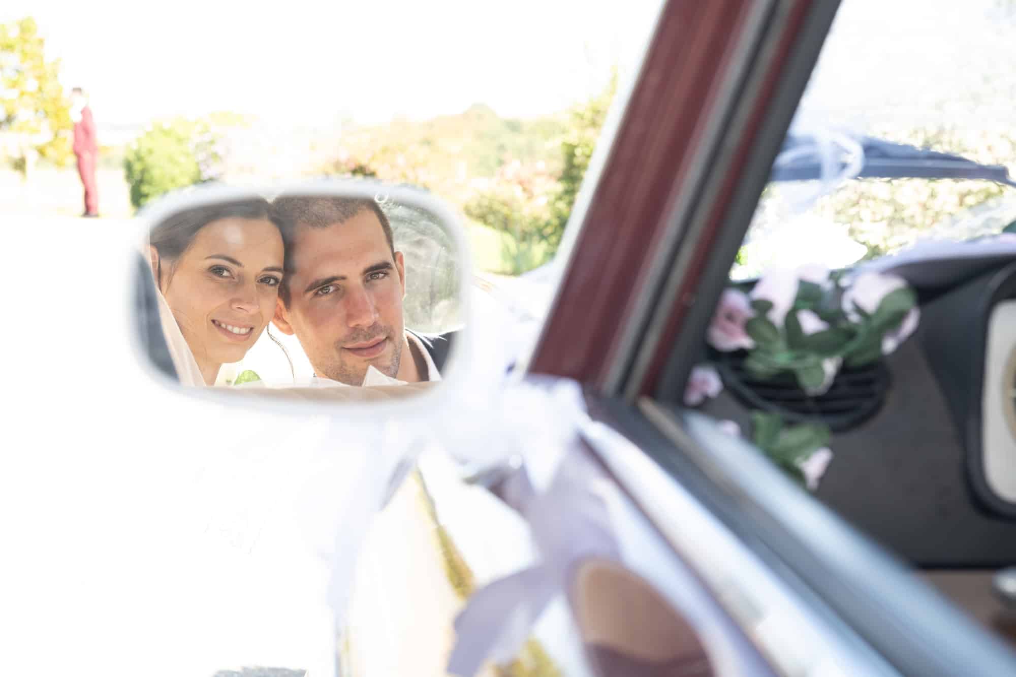 Portrait des mariés dans le rétroviseur pris par Arnaud M lors des photos de mariage à La Ferté-Gaucher pour Jason et Mathilde.